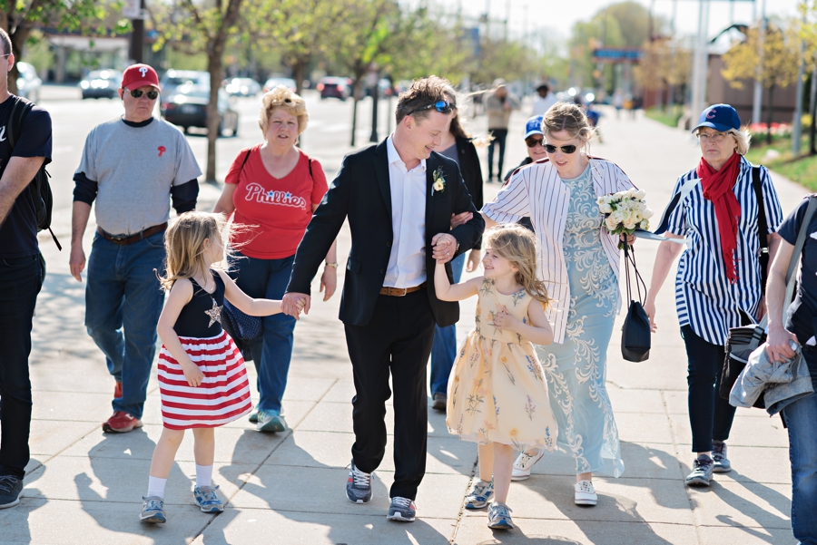 A couple walking with family on the way to their wedding reception at a Phillies game.
